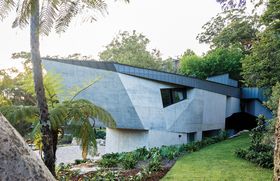 On arrival, visitors encounter a crescent-shaped house with a skin of angular concrete.