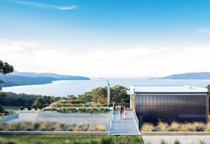 The house seems to sit on an axis that bisects the lake, the arc of two headlands, and the horizon of the ocean beyond.