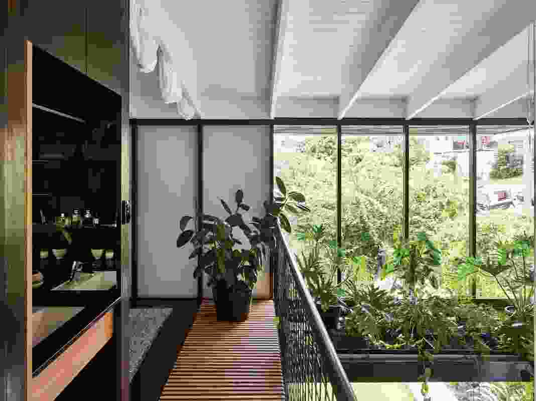 Framed by a suspended bed of lush plants, the large void provides connection between the upper and lower levels.