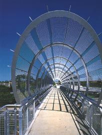 Daylight view along the bridge deck under the finely woven curved mesh sheath. Image: Ross Honeysett