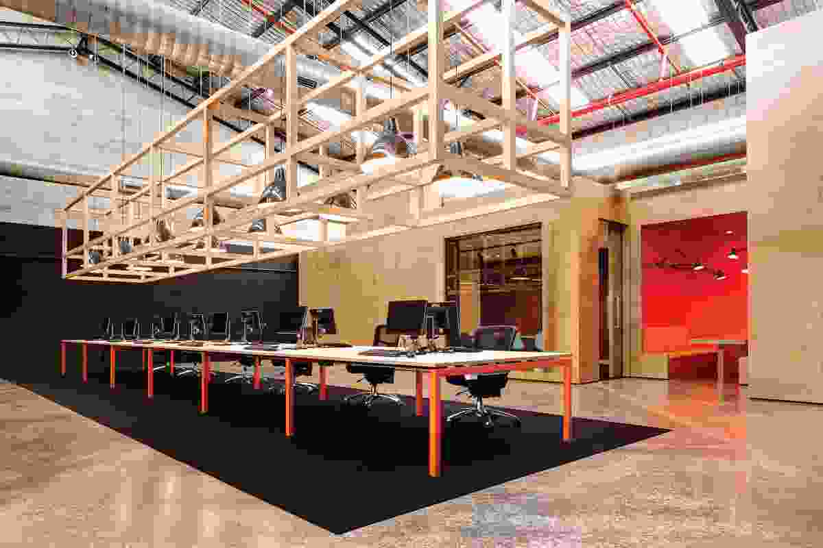 An open timber matrix is suspended above the central workstation.