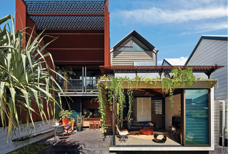 Additions unfold around an outdoor room, framed by a soaring steel portal.