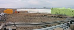 Panorama from behind the site, looking towards the bay with the operations building (yellow) and sleeping and medical quarters (green). Image: Adrian Young, AAD.