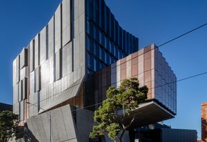 Concrete panels on the facade recede, tilt and fold to provide solar protection yet also reveal sliced silhouettes of life within. A dramatically cantilevered volume accommodates a recital hall.