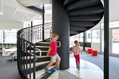 A spiral staircase makes a grand gesture in the centre of the two-storey volume.