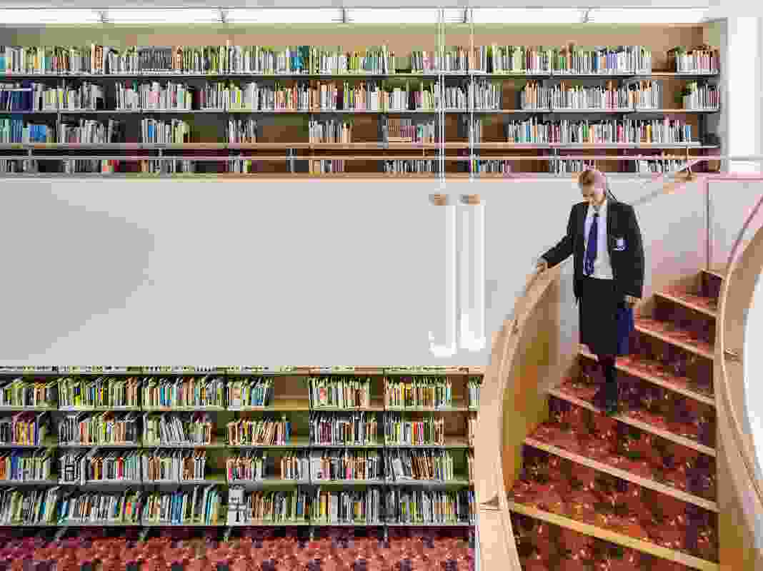 The book collection rooms are two-storey volumes with sweeping stairs that connect the floor levels.