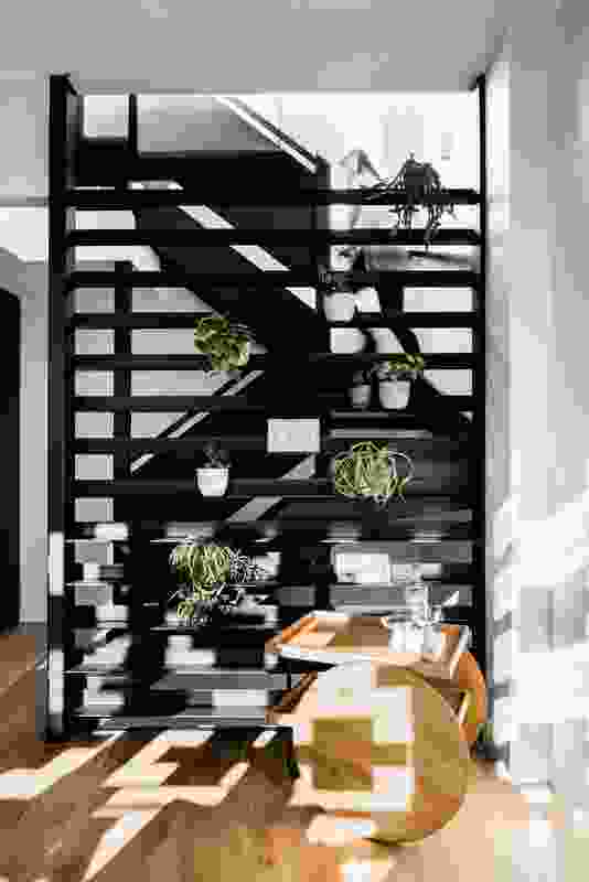 The exposed but screened stair emphasizes the “soaring verticality” of the living area.