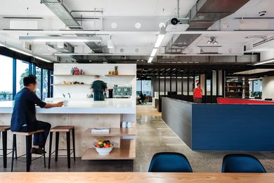 The office’s kitchen features a monolithic kitchen bench, with views to Sydney harbour.