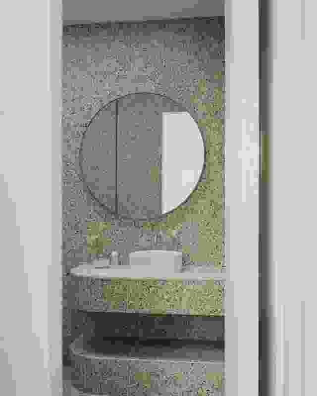 The ground-floor bathroom’s basin, mirror and terrazzo bench repeat a circular motif.