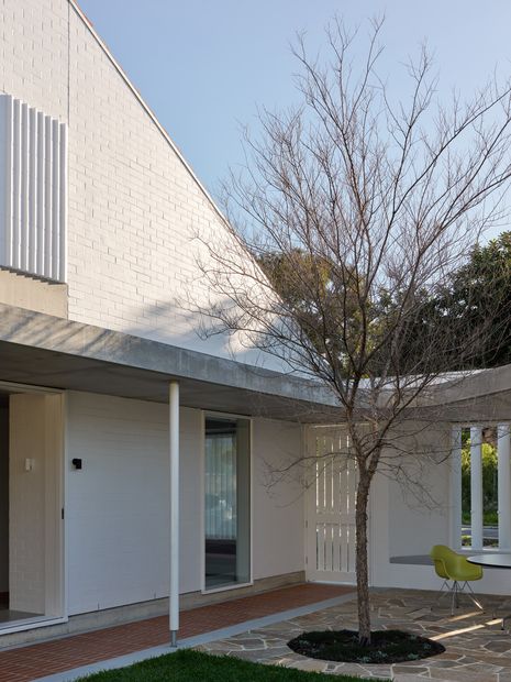 Bay windows and shutters balance outlook and privacy along the street edge.