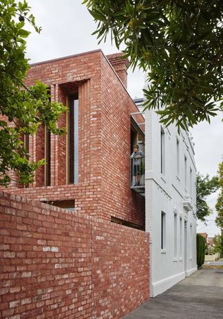 The new building is sleeved into the shell of the existing house.