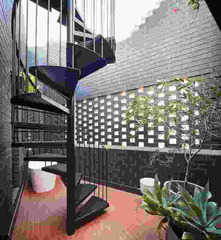 A hit-and-miss brick screen admits breezes to a private terrace while maintaining privacy.
