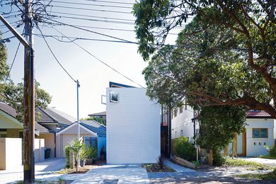 The clean, white boldness of the house’s facade offers visual respite in a street of mixed architectural styles.