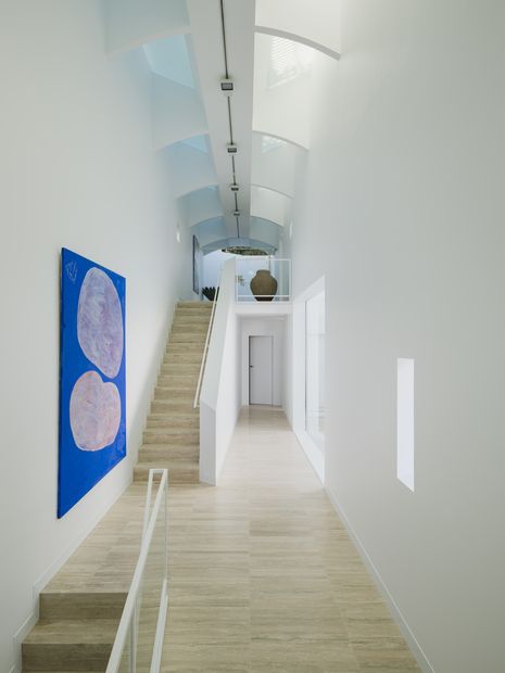 The stair is both circulation and gallery space, lit from above by a glazed butterfly roof.  Artwork: Ken Done.
