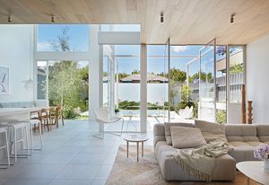 A steel frame extends the geometry of the house, mediating between living space and garden terrace. Artwork: Petrina Hicks.
