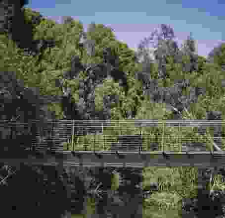 The bridge is positioned midway down the embankment, forming a closeness to the water.