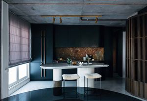 The marble of the kitchen’s bespoke island and splashback punctuate an otherwise moody colour palette.