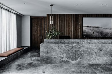 A honed dolomite reception counter appears morphed from the floor.