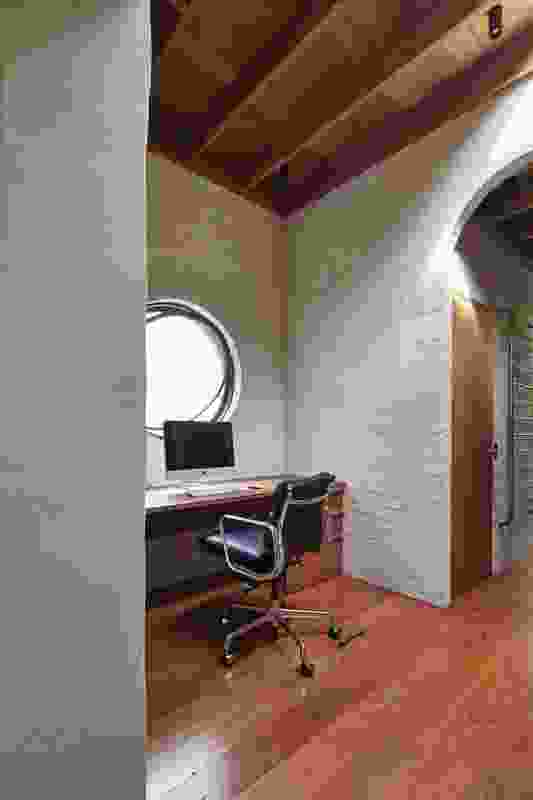 A circular pivot window in the study sits in conversation with the arched doorway.