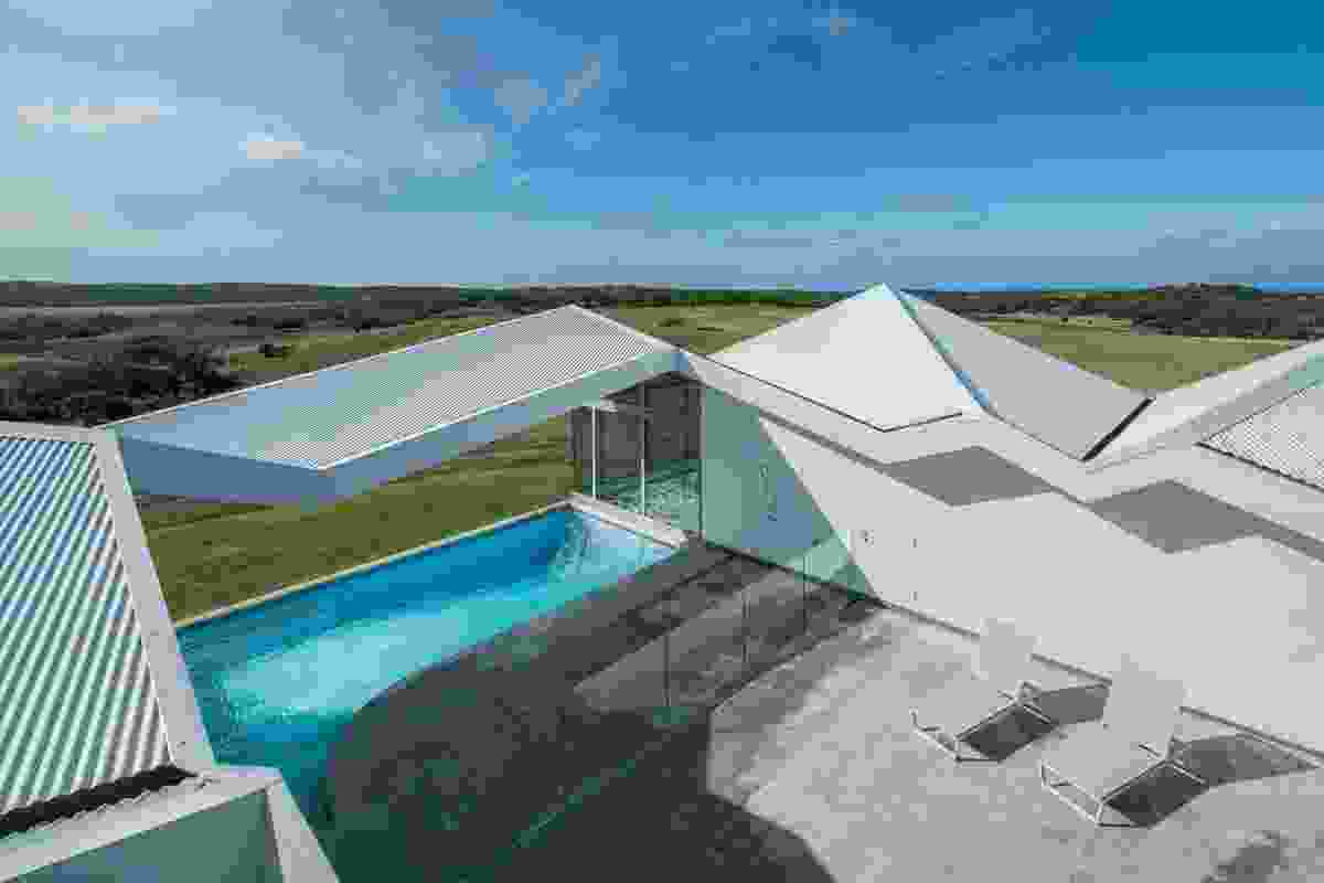 The central courtyard is open to the sky, while the roof folds over the pool as an open canopy.