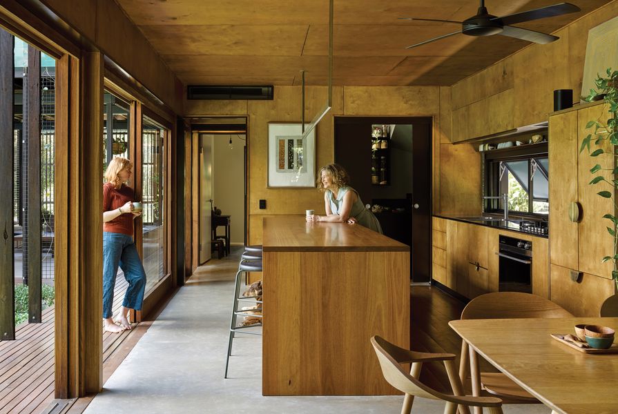 Solid blackbutt timber and stainless steel benches ground the kitchen with sleek yet sturdy style. Artworks (L–R): Graham Bligh, Willy Tjungurrayi.