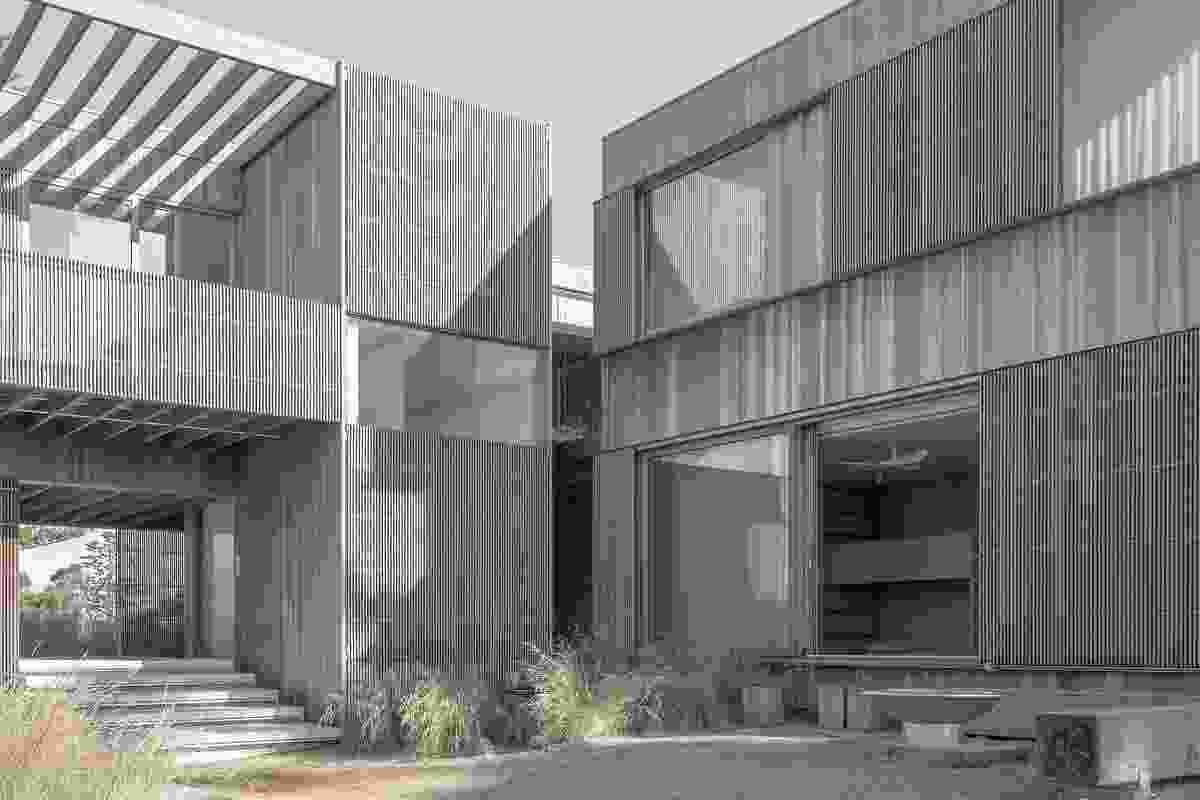 The house’s facade is simple and robust, wrapped in a skin of sun-bleached timber cladding that evokes the silvery swathe of the sand dunes.
