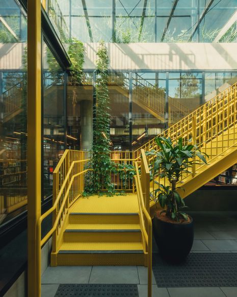 The library is accessed via a large stair at the end of one of the arcades that form connections across the site.