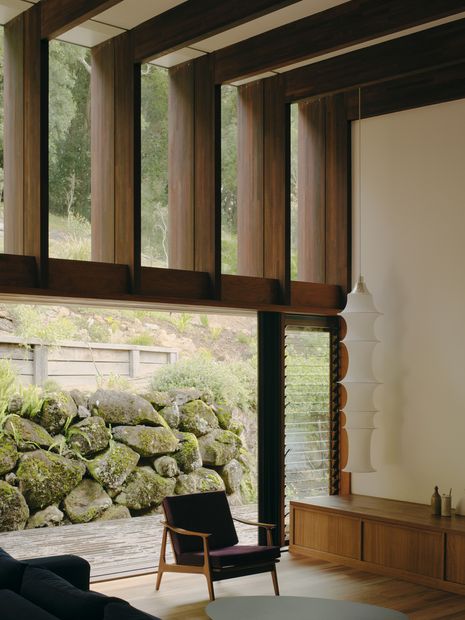 Glazing above the living room reaches to the canopy while vertical fins shade from the western sun.