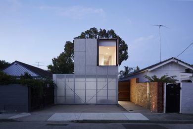 A polycarbonate skin fixed behind the facade perforations allows light to pass through, creating a radiating box and visual intrigue.