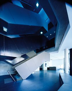 The dramatic scissor stair rises up the slim atrium space from the foyer. The intertwining black-and-white stairs lead to different destinations.