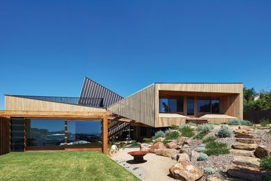 The upper pavilion stands above the rocky terrain, while the lower pavilion is embedded in the flatter part of the site.