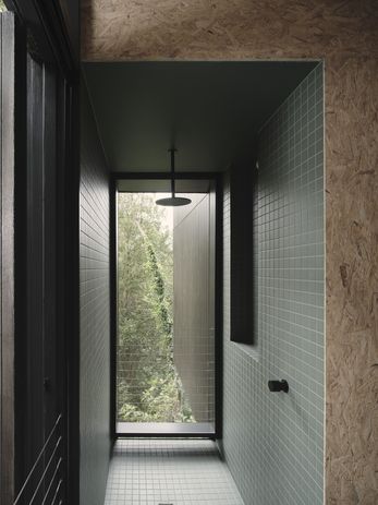 The bathroom is wrapped in a uniform surface of dark grey tiles.