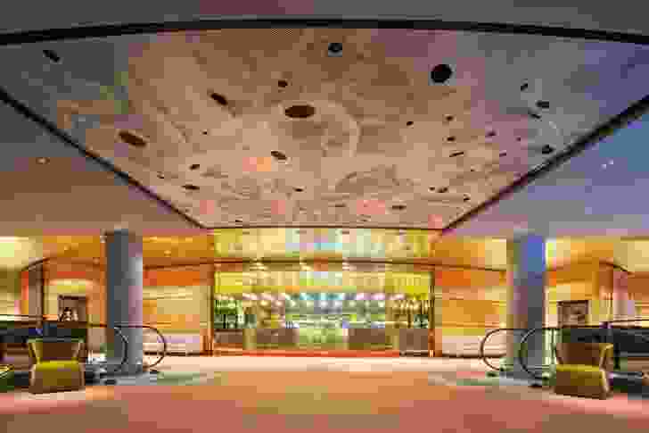 The view across the refurbished dress circle foyer to one of the many new bars. A newly commissioned artwork by Robert Owen, Falling Light, can be seen on the ceiling.