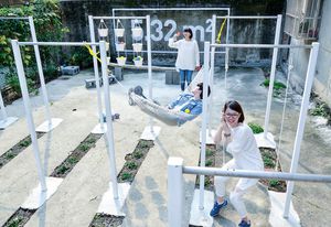 Steel horizontal bars serve as scaffolding for a variety of uses at the ParkUp community gathering site in Taipei, Taiwan designed by Plan b.