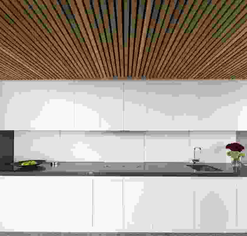 The minimalist kitchen runs along one edge of the dining space. 