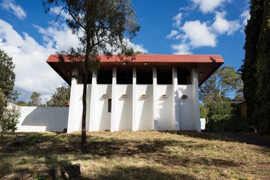 The Evans House is set well back from the road on a sharp slope, rising fortress-like from the hillside.