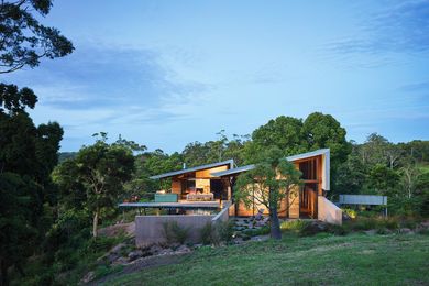 The roofs of the two pavilions follow the line of the landscape, while indoor and outdoor living spaces are suspended above the slope.