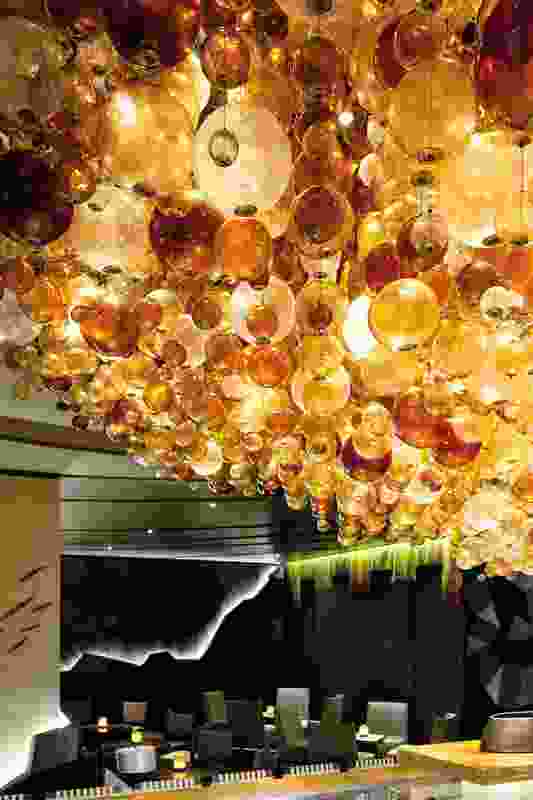 Hand-blown glass orbs hang in clusters providing a series of centrepieces through the space.