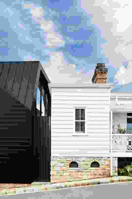 Inky black metal cladding combined with painted white weatherboard makes for an eclectic yet unified palette.